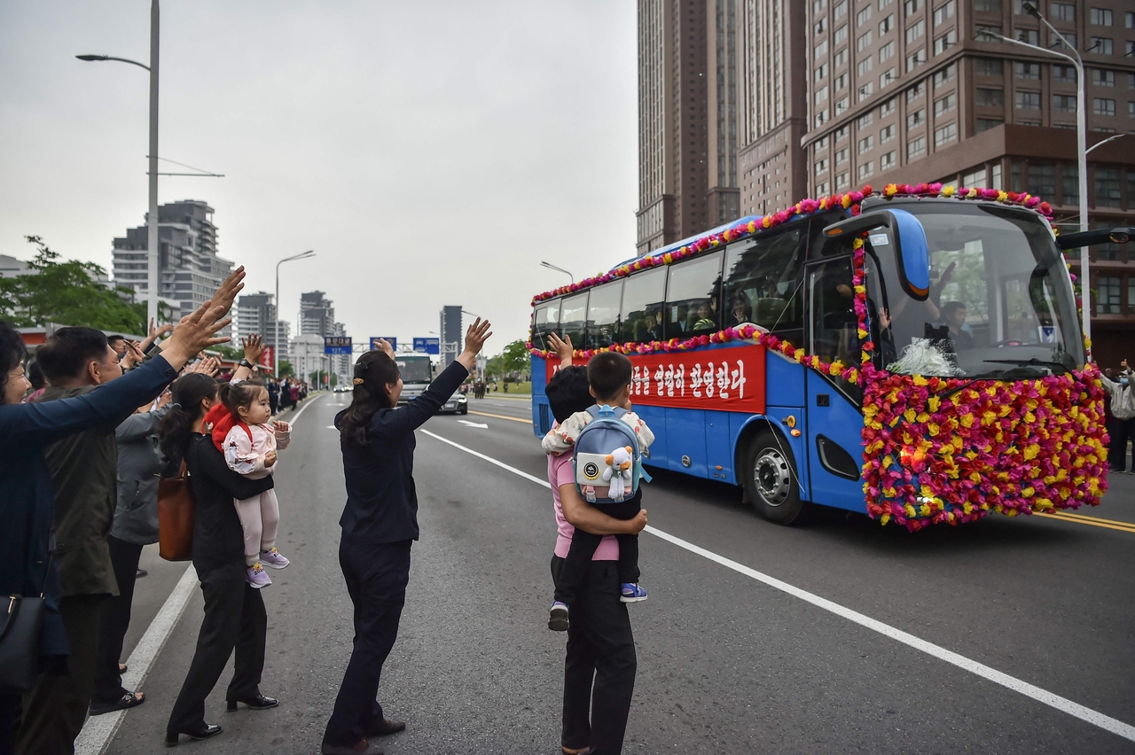 People gather on a street to welcome members of North Korea's team, who won the 2026 AFC U-17 Women's Asian Cup in China, after their arrival in Pyongyang on Tuesday. (AFP-Yonhap)