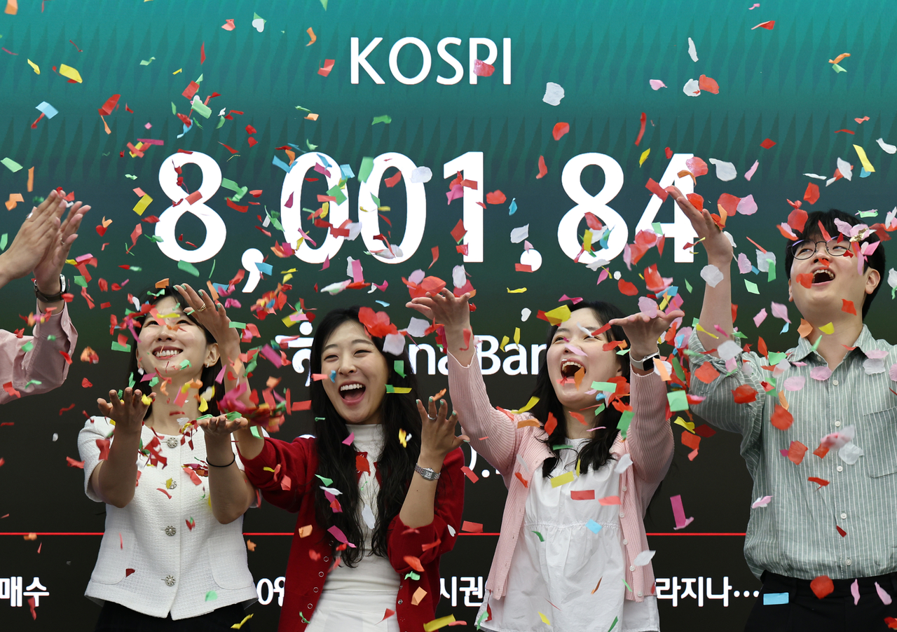 Employees take part in a ceremony at the dealing room of Hana Bank in Seoul on May 15 to celebrate the benchmark Kospi having risen over the 8,000-point mark for the first time in early trading. (Yonhap)