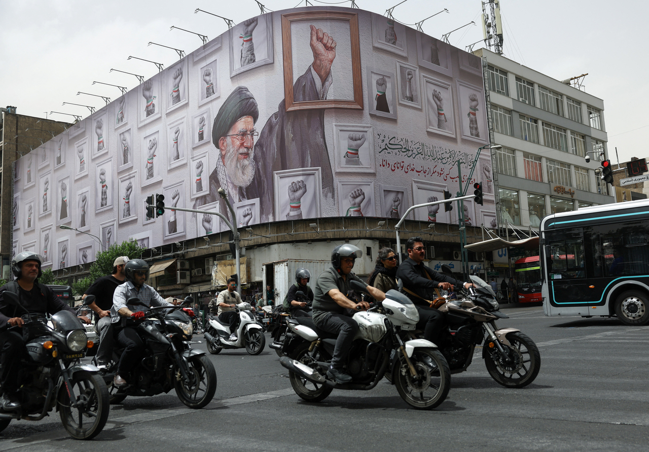 People ride motorcycles near a billboard with an image of the late Iranian Supreme Leader Ayatollah Ali Khamenei, in Tehran, Iran, Tuesday. (Reuters-Yonhap)