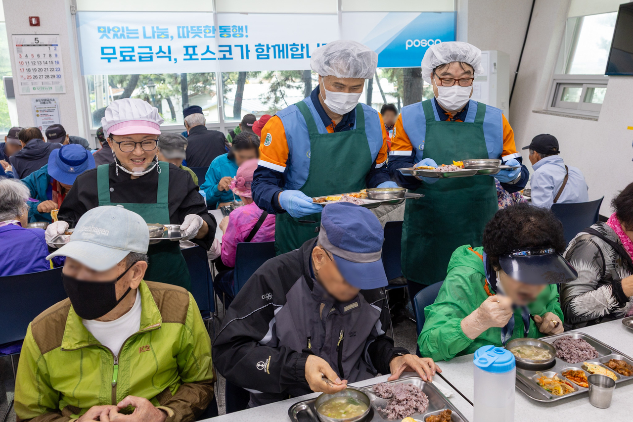 Standing, from left: Chef Lee Mi-young, Posco President Lee Hee-geun and Oh Chang-seok, a master steelmaker at Posco, participate in a special volunteer meal service event held at Songrim Senior Welfare Center in Songdo-dong, Pohang. (Posco)