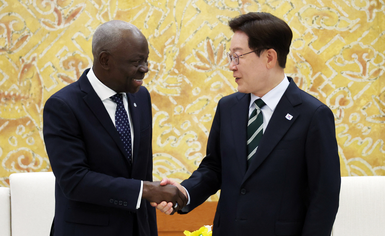 President Lee Jae Myung (right) and International Labor Organization Director-General Gilbert Houngbo shake hands at Cheong Wa Dae in Seoul on Friday. (Yonhap)