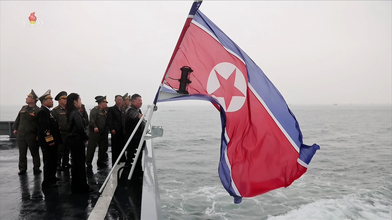 A North Korean flag flies on a warship on May 8 as North Korean Supreme Leader Kim Jong-un observes a military drill. (Yonhap)
