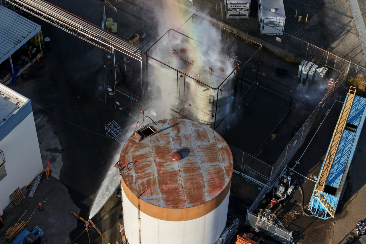 A drone picture shows water being sprayed on a tank as a chemical incident involving a failing tank of flammable liquid called methyl methacrylate, used in the aerospace industry, has forced an evacuation in the surrounding area in Garden Grove, California, US on Friday. (Reuters/ Yonhap)