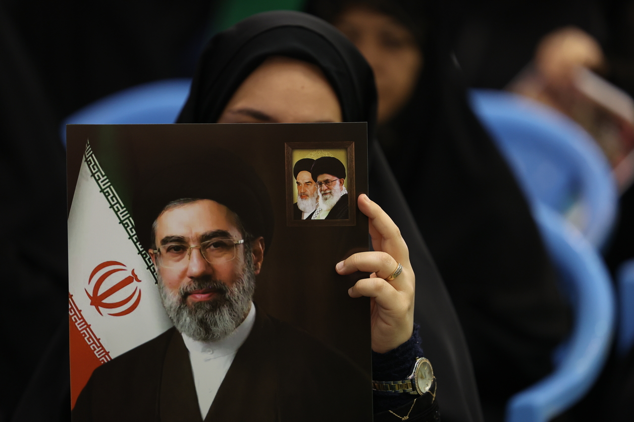 An Iranian woman holds a picture of Iranian Supreme Leader Ayatollah Mojtaba Khamenei during a memorial ceremony for those killed in the Iran-US-Israel war at Mosallah Mosque in Tehran, Iran, 24 May 2026.  (EPA-Yonhap)