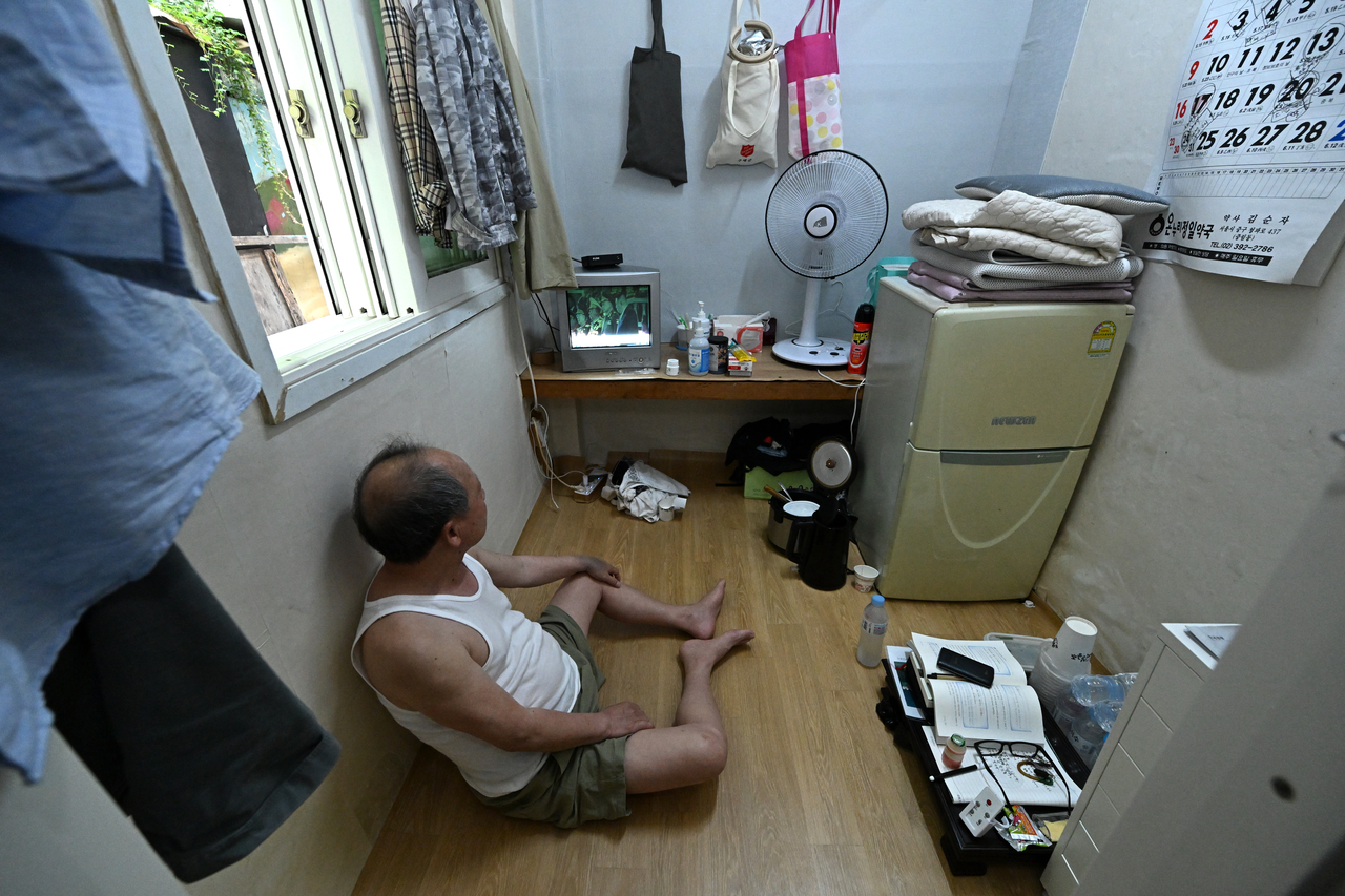 A resident watches television in a small single-room unit in a jjokbang village in Dongja-dong, Yongsan-gu, central Seoul, where many low-income single-person households are concentrated. (Im Se-jun/The Korea Herald)