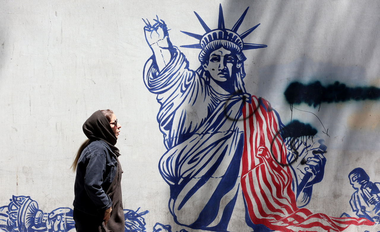 An Iranian woman walks next to an anti-US mural near to the former US embassy in Tehran, Iran, on Tuesday. (EPA-Yonhap)
