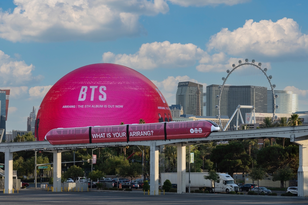 The Sphere, lit up in red as well as a monorail wrapped in red visuals and the slogan