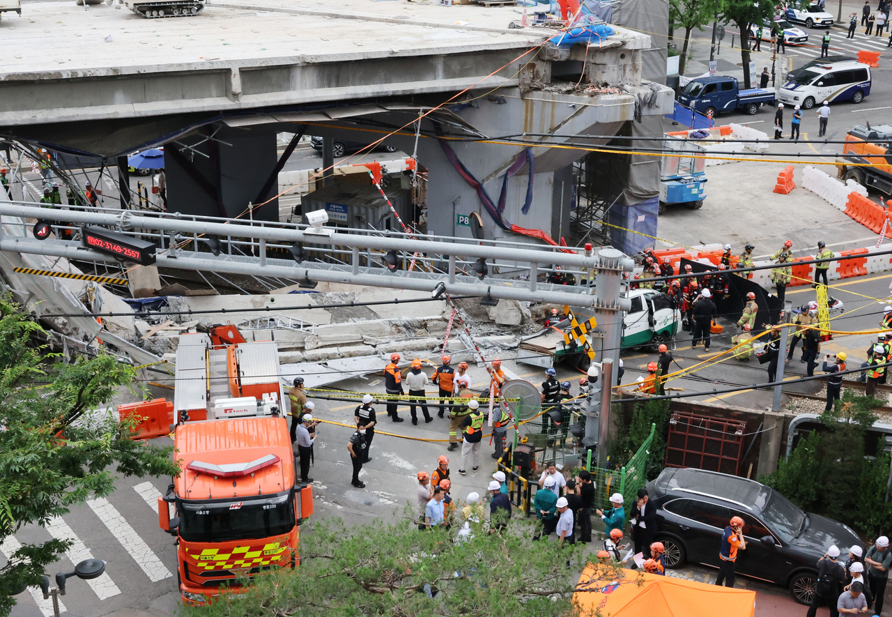 Fire authorities are seen at the site where part of the Seosomun overpass collapsed during demolition in Seodaemun-gu, Seoul, Tuesday. (Yonhap)