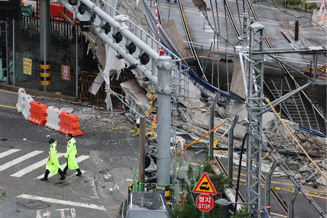 Police officers conduct an onsite investigation at the site of a deadly overpass collapse in Seodaemun-gu, Seoul, Wednesday. (Yonhap)