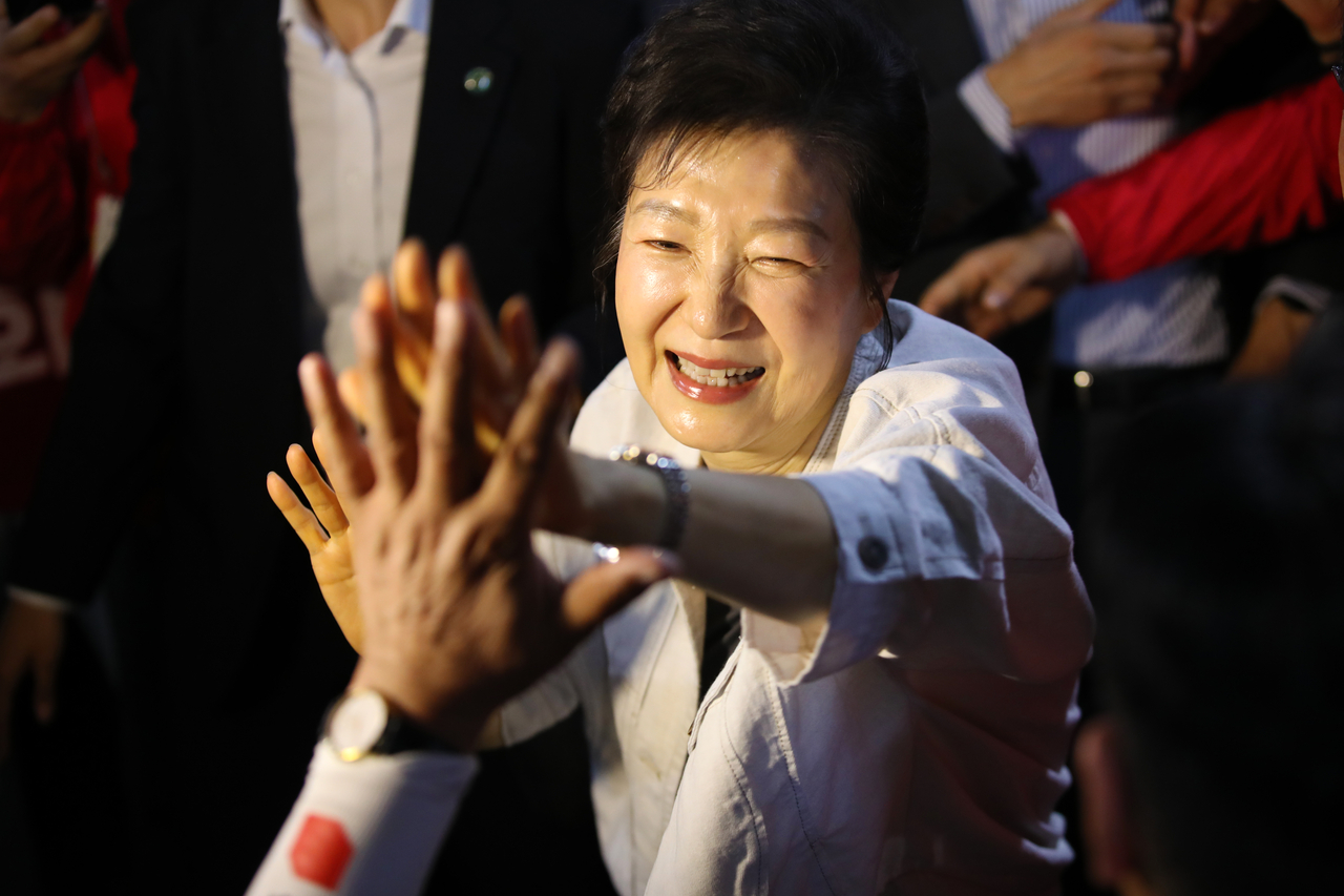 Former President Park Geun-hye greets a supporter at a local election campaign event held in Daejeon on Monday. (Pool photo via Yonhap)