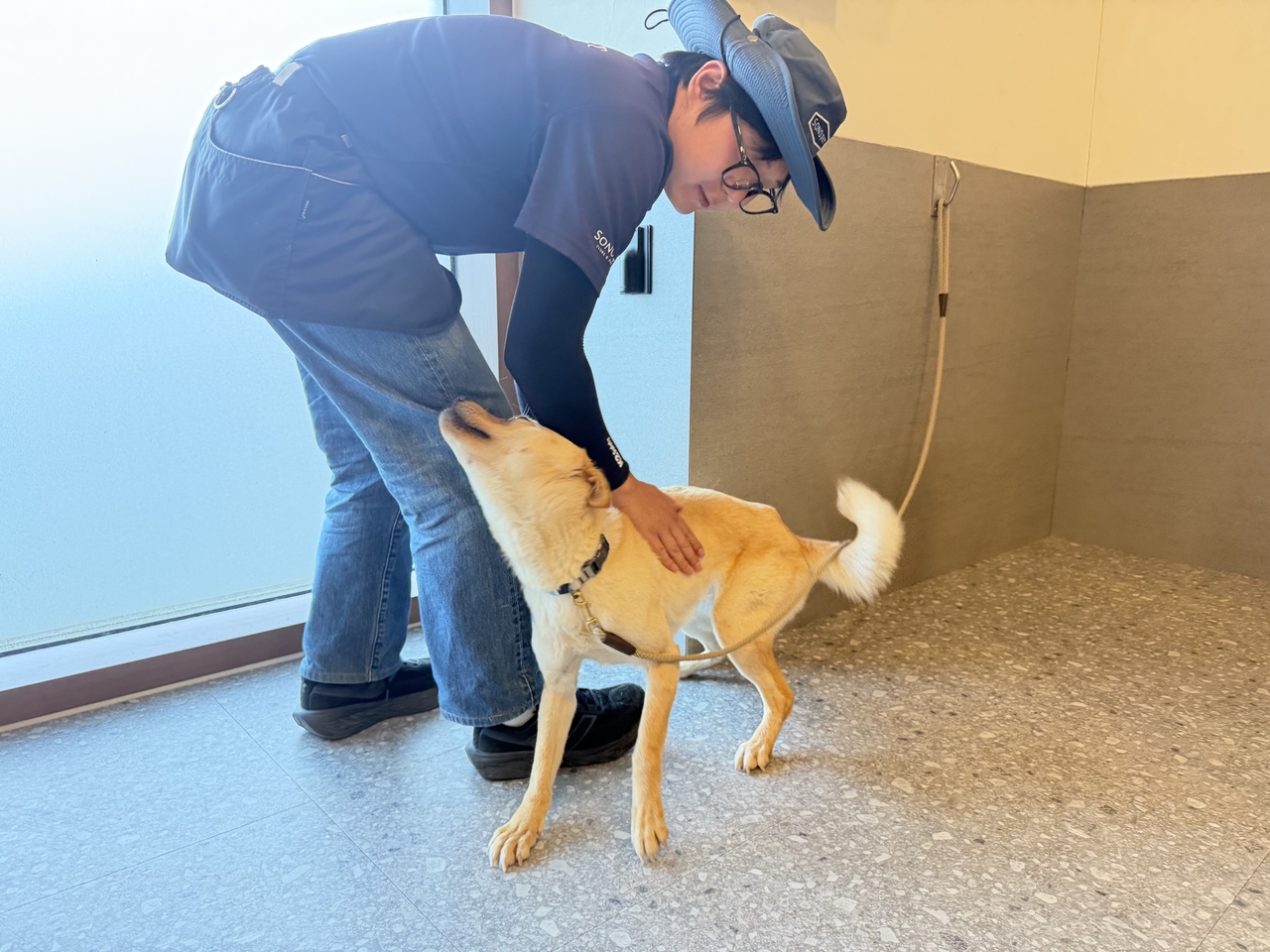 Rescue dog Deoksoon sheltered at Sono Pet Club & Resort in Hongcheon, Gangwon Province, with her trainer Maki (Hong Yoo/The Korea Herald)