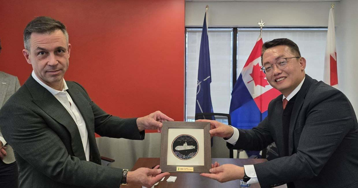 Park Yong-yeol (right), head of Naval Ship Division at HD Hyundai Heavy Industries, and James Davies, CEO of Davie Shipbuilding, pose for a photo during a visit to Davie’s Ottawa office on Tuesday. (HD Hyundai Heavy Industries)