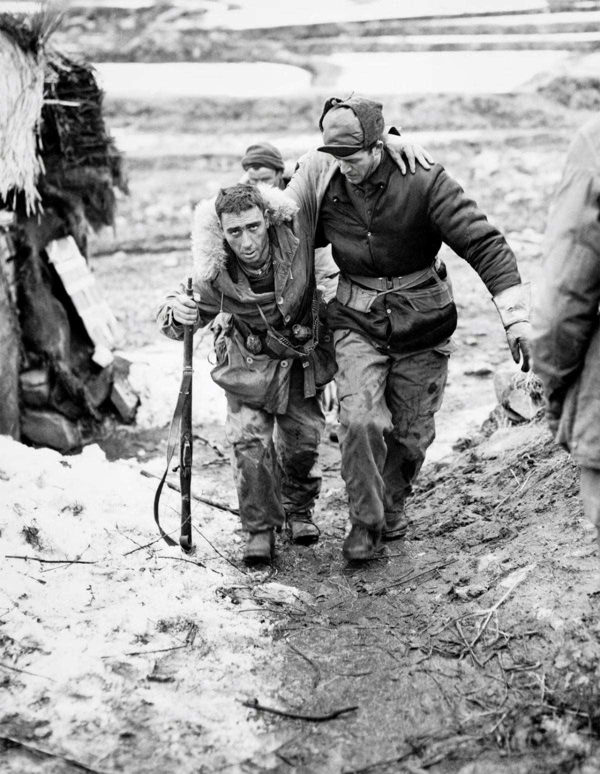 A Canadian Korean War veteran, William J. Chrysler (right), helps a wounded comrade. (Canadian Embassy)