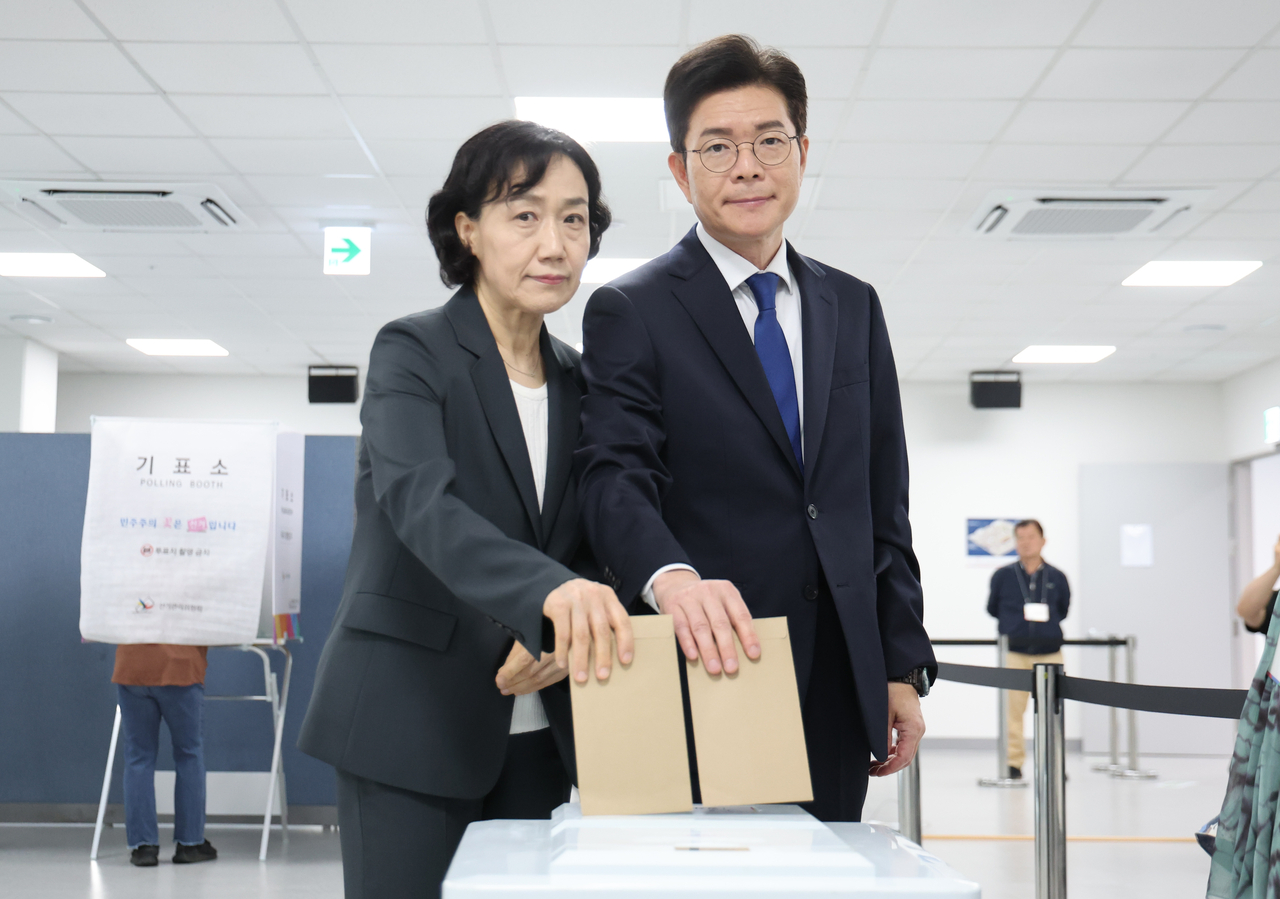 Seoul mayoral candidate Chong Won-o (right) of the ruling Democratic Party and his wife Moon Hye-jung cast their early votes at a polling station in Jung Ward, central Seoul, on Friday ahead of the June 3 local elections. (Pool photo via Yonhap)
