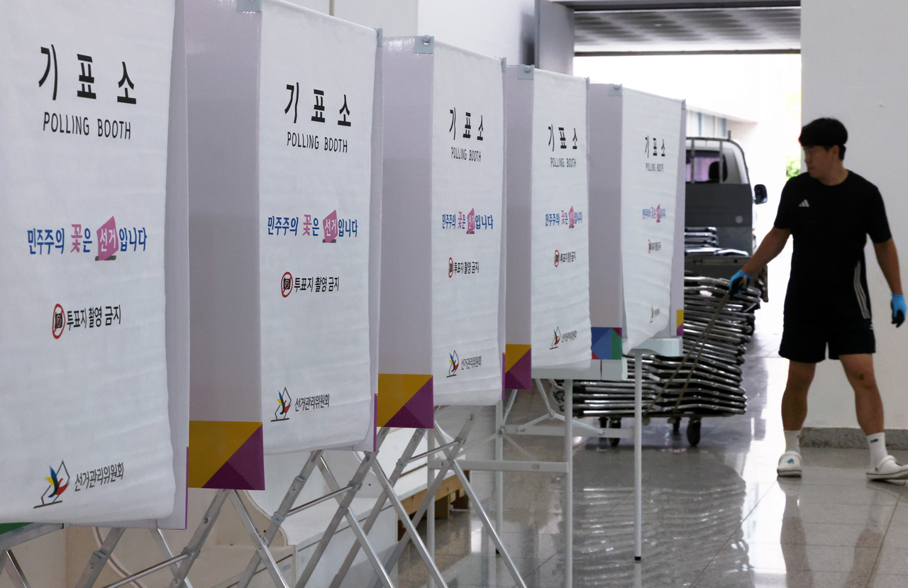 An employee sets up a polling booth at a polling station in the southwestern city of Gwangju on Thursday, one day ahead of the start of a two-day early voting period for the June 3 local elections. (Yonhap)
