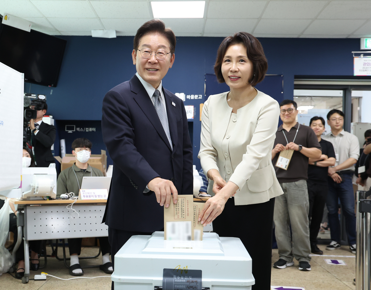 President Lee Jae Myung and first lady Kim Hea Kyung cast their ballots during early voting for South Korea’s ninth nationwide local elections at a polling station set up inside the Samcheong-dong community center in Seoul’s Jongno-gu on Friday. (Cheong Wa Dae via Yonhap)