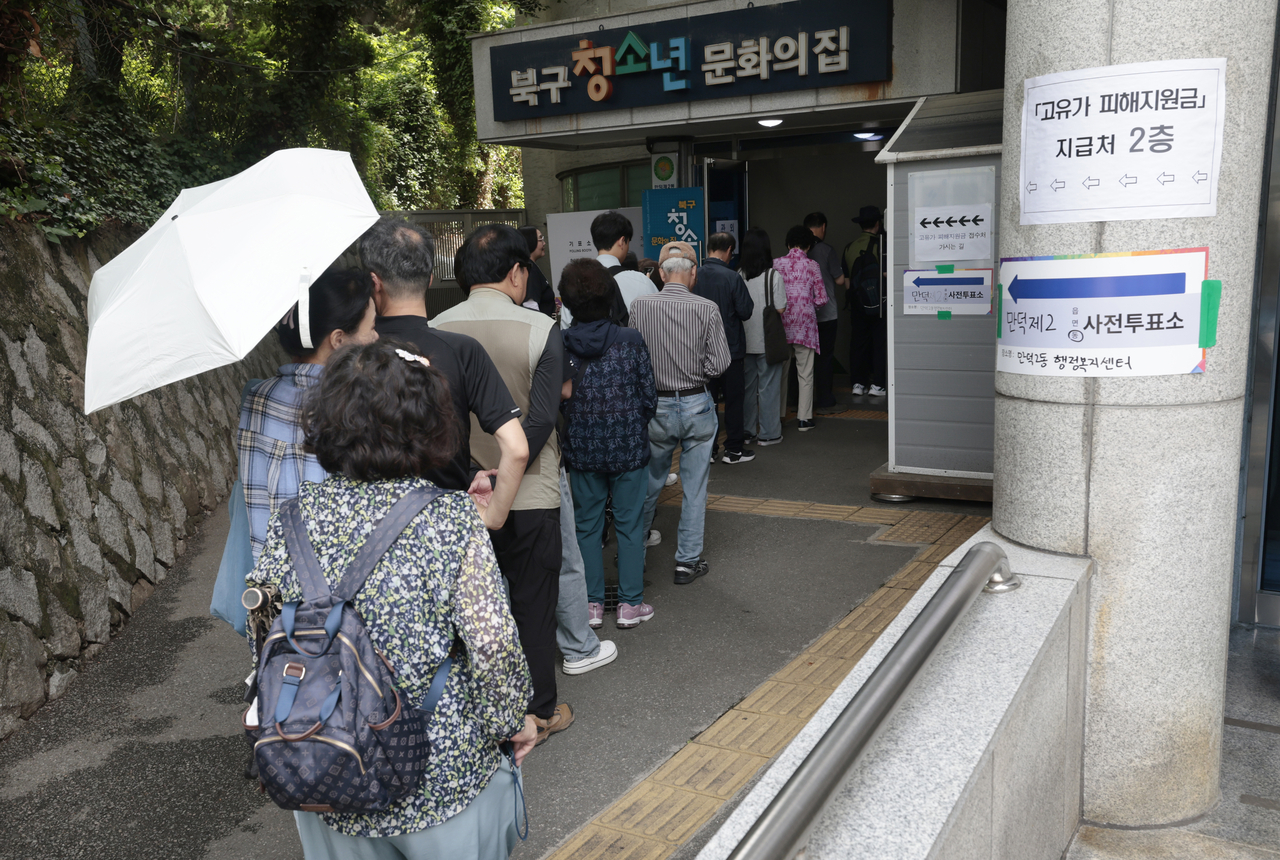 People queue up to cast their votes in Busan on Friday. (Yonhap)