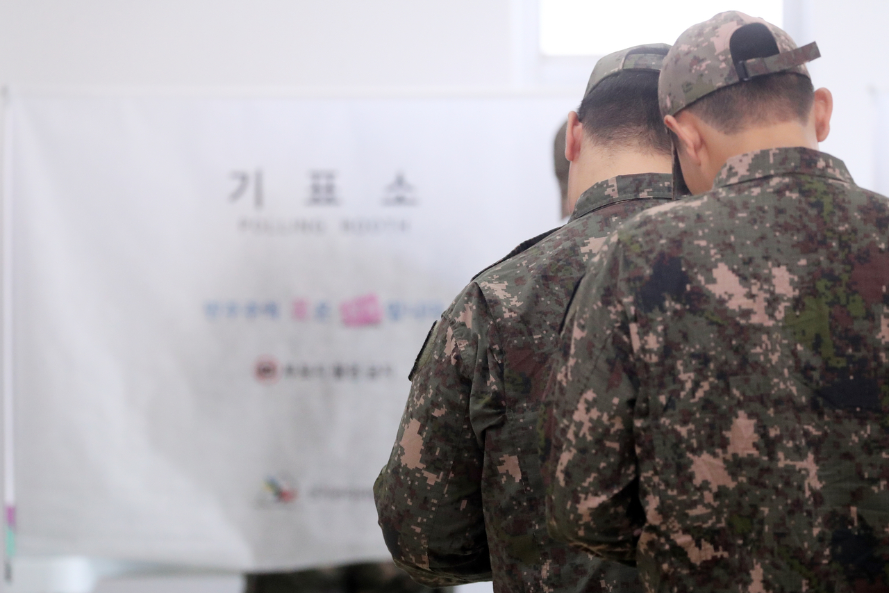 Soldiers wait in line to cast ballots at an early voting station in Goseong County, Gangwon Province, on Thursday, the first day of two-day early voting for South Korea’s ninth nationwide local elections. (Yonhap)