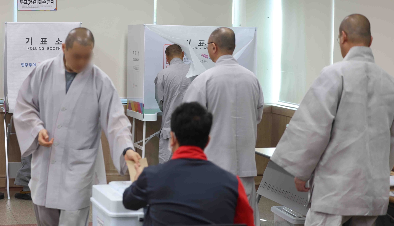 Buddhist monks cast their ballots at a polling station in Yangsan, Gyeongsang-do, on Friday. (Yonhap)