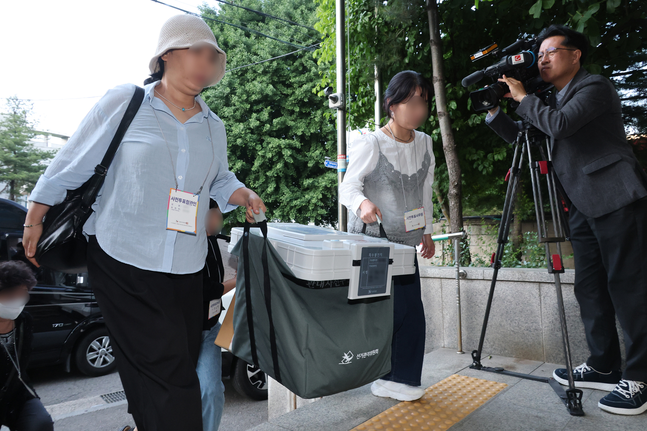 Election officials move early voting ballot boxes for local voters to a storage area at the Yongsan District Election Commission on May 29. (Yonhap)