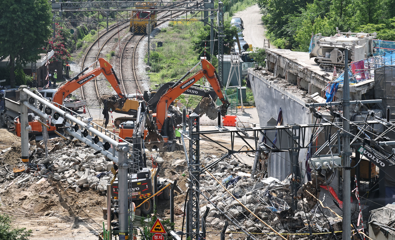 Workers carry out emergency demolition work at the site of the collapsed Seosomun overpass in Seoul on May 29. (Yonhap)