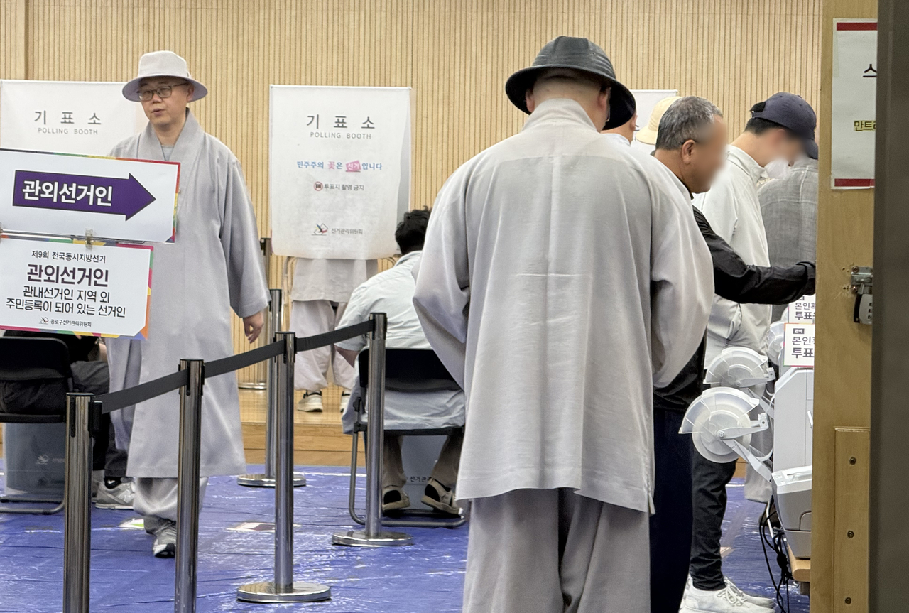 Monks from Jogyesa Temple, including Vice Abbot Tanbo, cast their ballots at an early voting station in Seoul's Jongno-gu on Saturday. (Yonhap)
