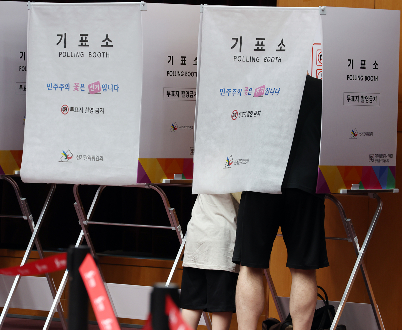 A child joins his father in a voting booth at an early voting station at the Jeonbuk Provincial Government complex on Saturday. (Yonhap)