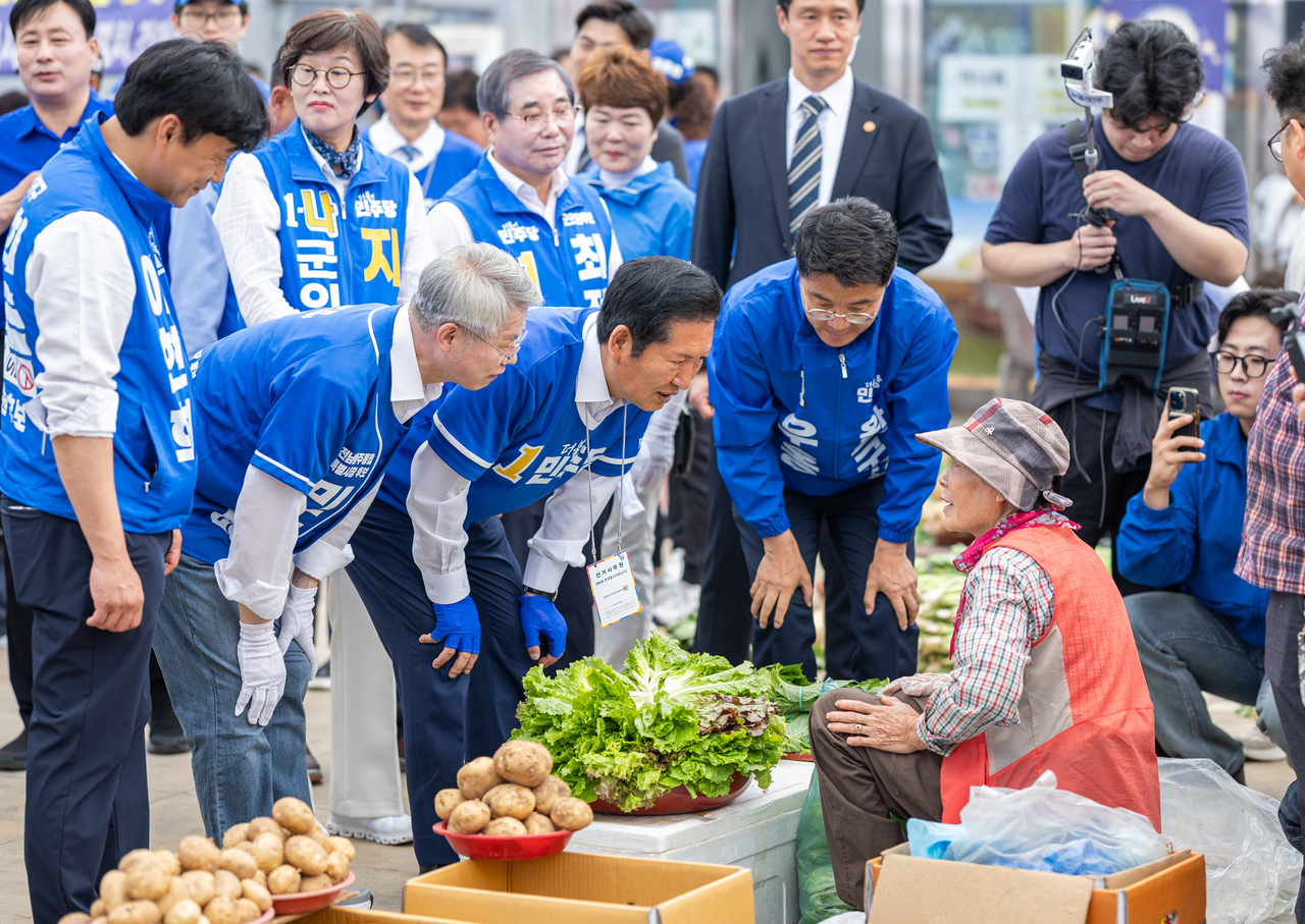 Democratic Party election campaign chief Jung Chung-rae greets merchants at Wando General Market in South Jeolla Province on Saturday while campaigning alongside local candidates. (Yonhap)