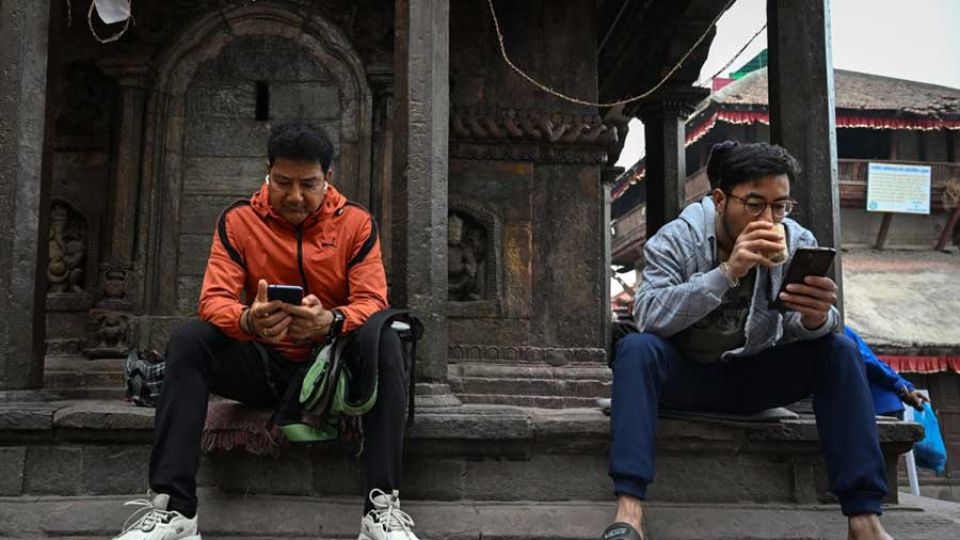 Nepali people look at their phones, at a street in Kathmandu, nepal.    (Kathmandu Post)