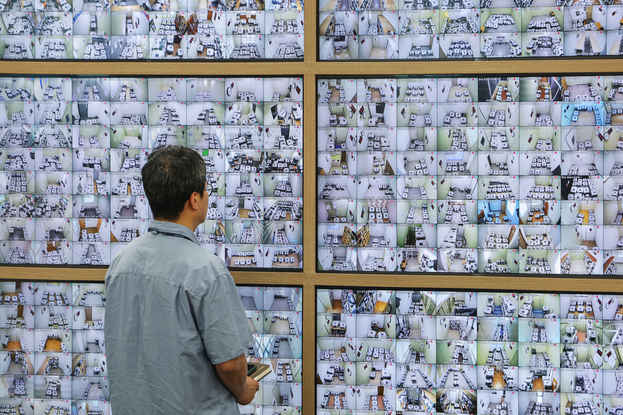 An official at the National Election Commission in Gwacheon, Gyeonggi Province, monitors locations storing ballot boxes from early voting via closed-circuit TV on Sunday, as the country is set to hold elections Wednesday. (Yonhap)