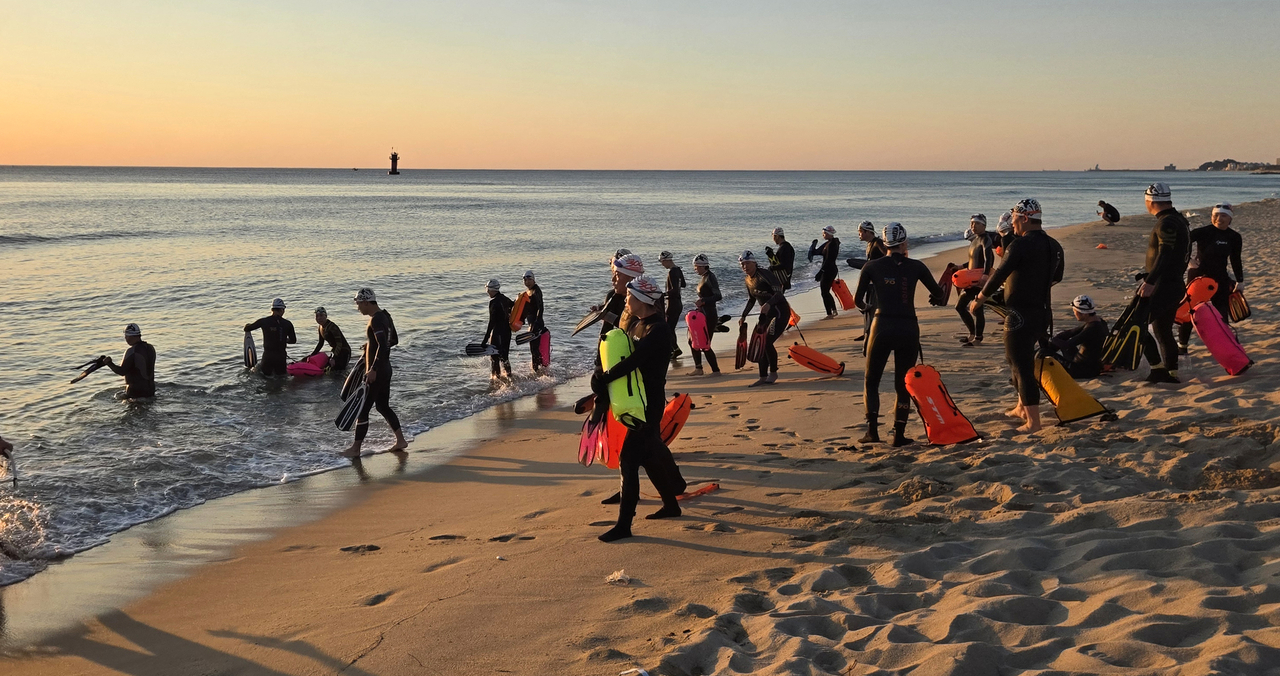 Sea swmming crews dive into the beach at Gyeongpo Beach in Gangneung, Gangwon Province, early Sunday. (Yonhap)