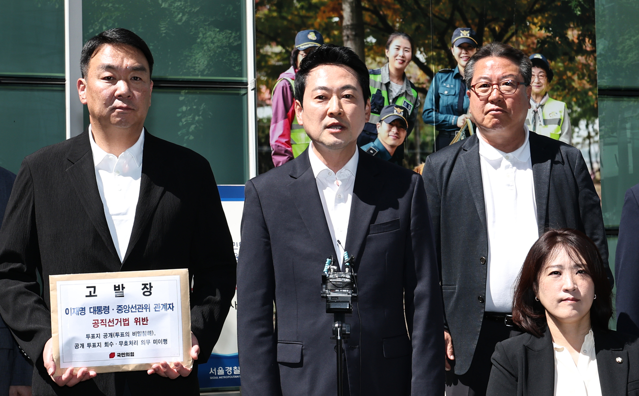 People Power Party Reps. Jang Dong-hyeok (second from left), and Jung Hee Yong (left) are seen Saturday as they were submitting a complaint with police against President Lee Jae Myung for violating the Public Official Election Act. (Yonhap)