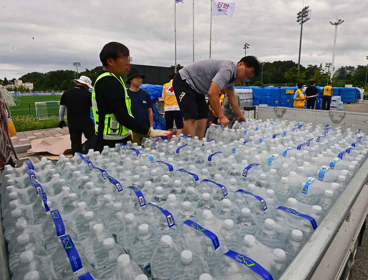 강원 강릉시 강남동 강남축구공원에서 주민들에게 생수를 나눠주고 있다.[연합]