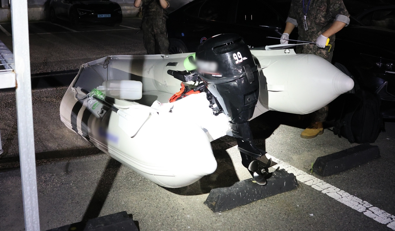 Authorities in Taean, South Chuncheong Province examine the rubber boat Dong arrived in on Wednesday. (Yonhap)
