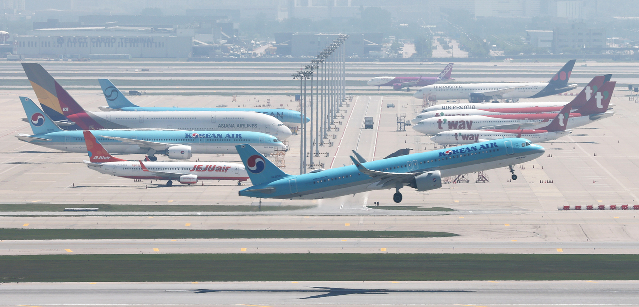 Aircraft are lined up on the tarmac at Incheon International Airport in Incheon on Sunday. (Yonhap)