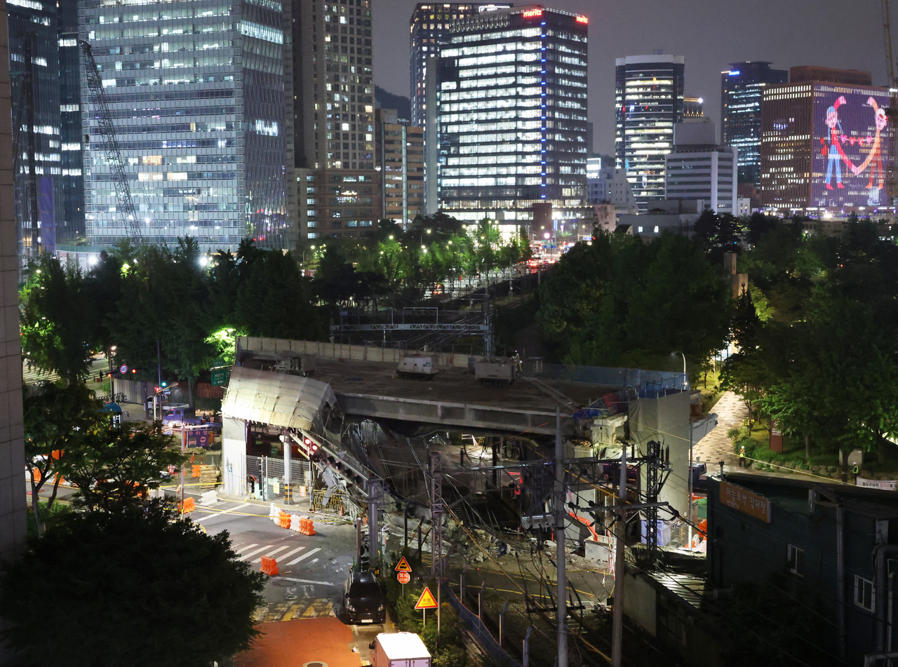 The site of a collapsed section of the Seosomun Overpass in western Seoul is illuminated at night, May 26. (Yonhap)