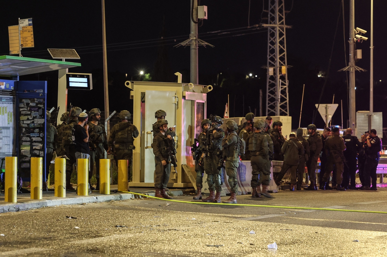 Israeli soldiers stand at the scene of an attack at the West Bank on Sunday. (AFP-Yonhap)