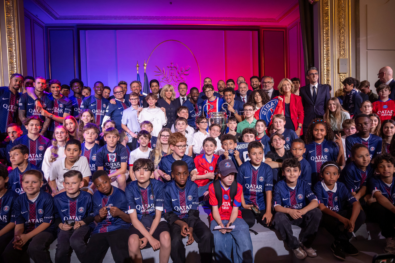 French President Emmanuel Macron (top center) poses with children and Paris Saint-Germain players with the trophy during a reception at the Elysee Palace in Paris, Sunday.    (Reuters-Yonhap)