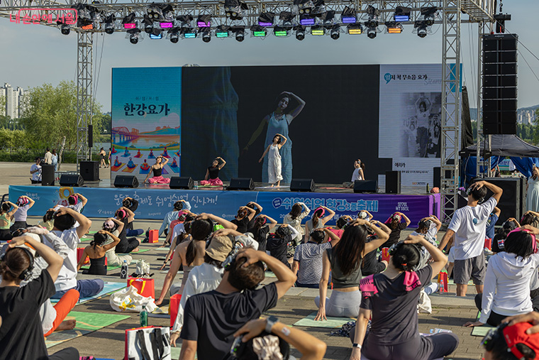 Participants follow an outdoor yoga session during the 1st My Pace Hangang Triathlon Festival at Han River Park in Seoul in June 2024. (Seoul Metropolitan Government)