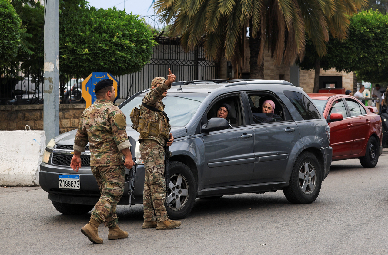 A member of the security personnel gestures gesture while standing on a road as people make their way while they flee the southern suburbs of Beirut, after Israeli Prime Minister Benjamin Netanyahu ordered the military to attack targets in the suburbs, Lebanon, Monday. (Reuters-Yonhap)