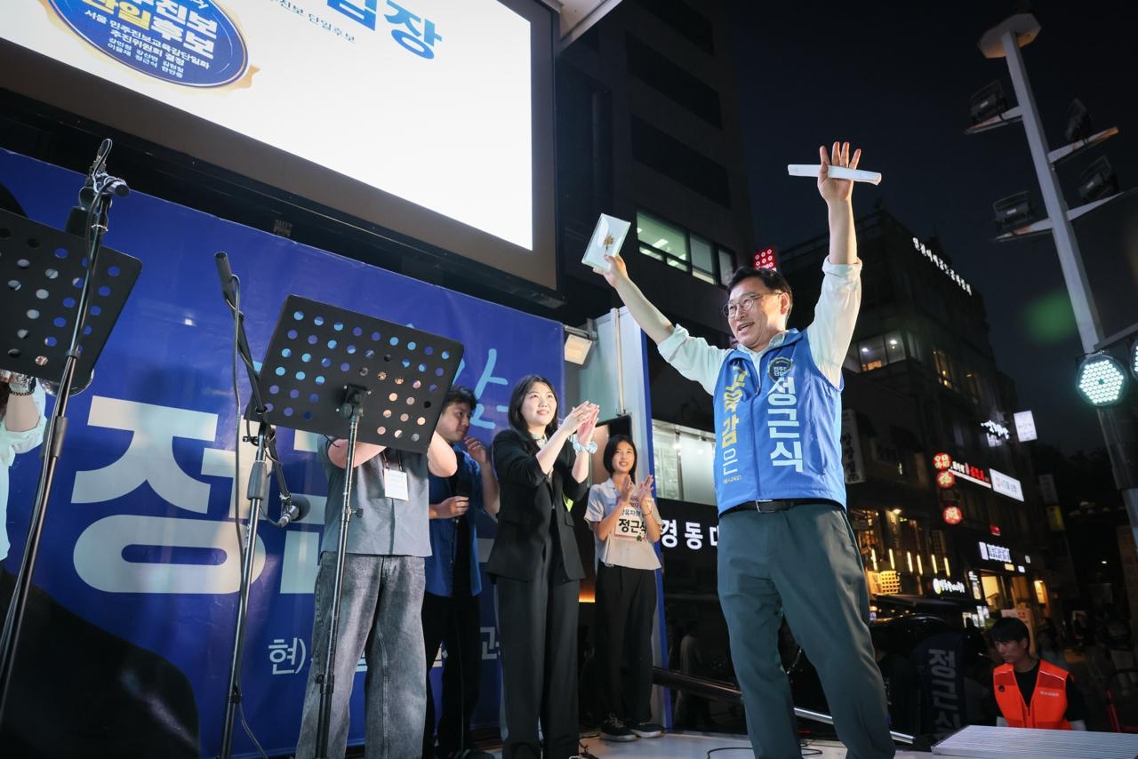 Liberal Seoul Metropolitan Education Superintendent candidate Jung Geun-sik (right) raises his hands to cheer during his final rally on Tuesday in front of Deoksugung in Jung-gu, Seoul. (Jung Geun-sik's campaign office)