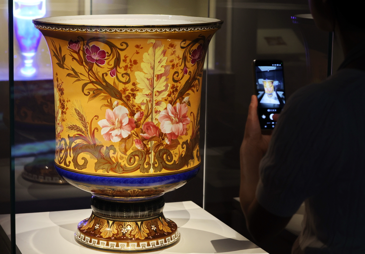 A visitor takes a photo of a painted white porcelain salamina vase at the exhibition "Gifts and Records: 140 Years of Korea-France Friendship" at the National Palace Museum of Korea in Seoul on Tuesday. (Yonhap)