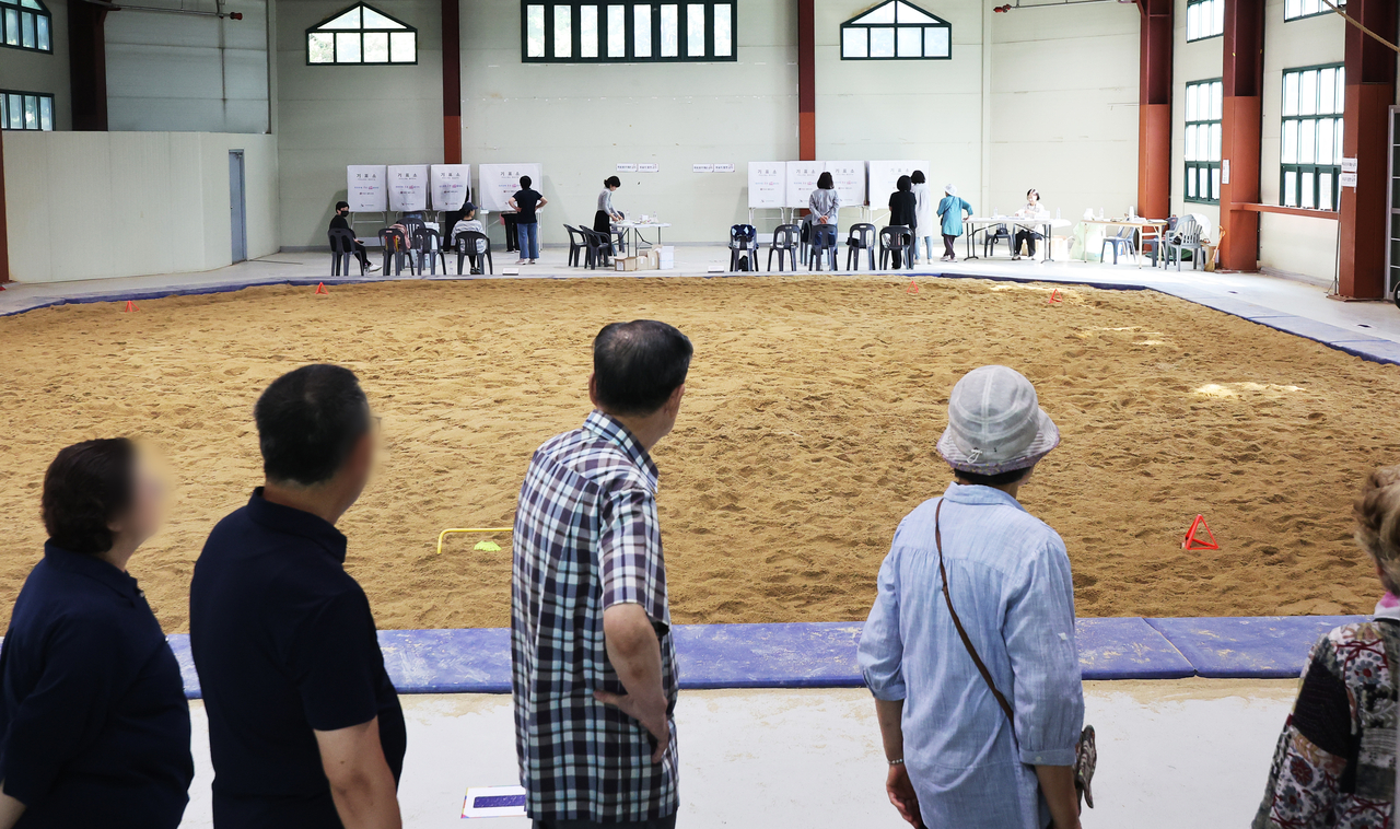 People cast their ballots at an indoor wrestling arena serving as a polling station in Seongnam on Wednesday. (Yonhap)