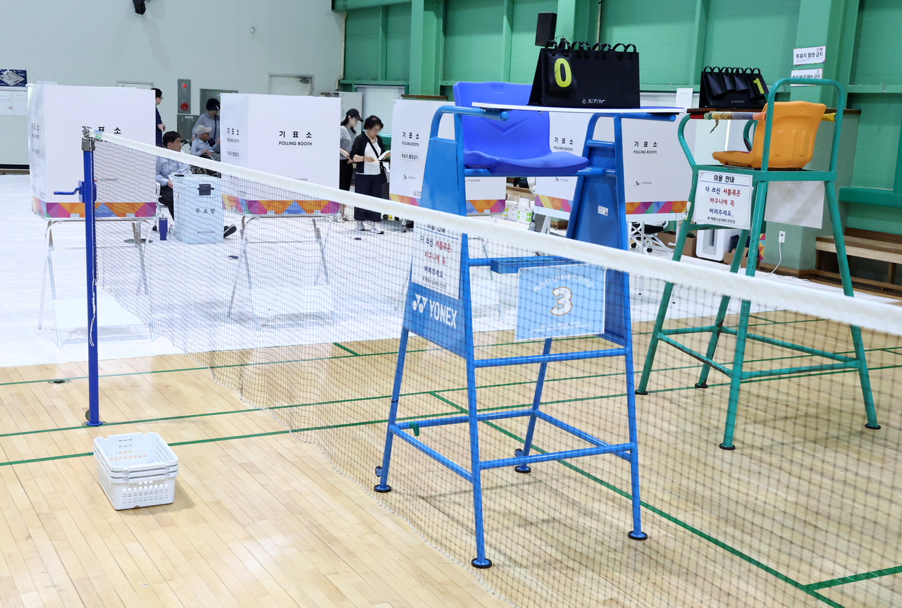 People vote at an indoor badminton court serving as a polling station in Seoul on Wednesday. (Yonhap)