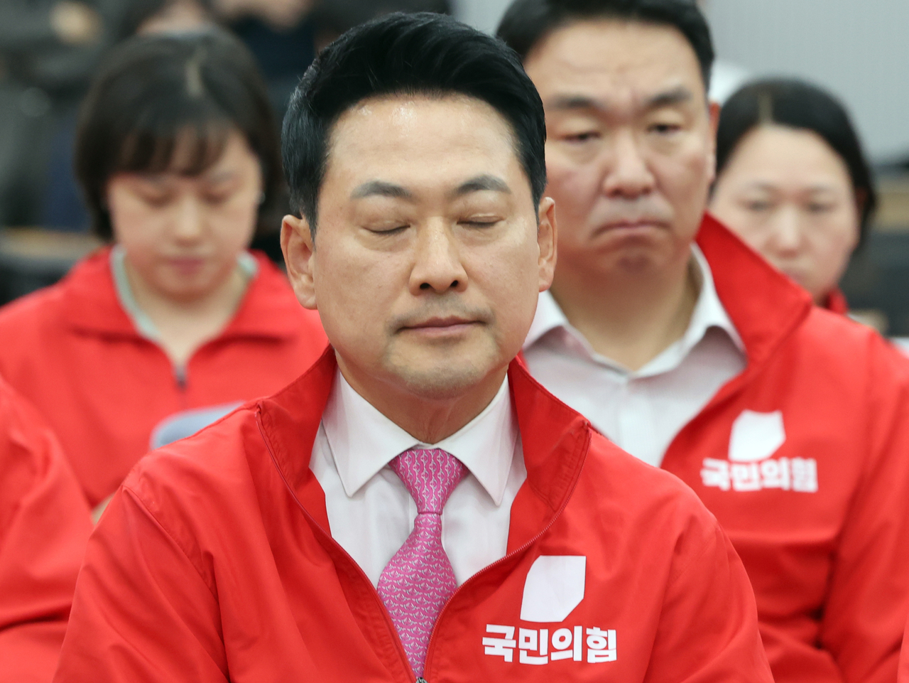 People Power Party chair Rep. Jang Dong-hyeok (center, front) closes his eyes as the exit poll results for the election are broadcast at the People Power Party headquarters in Seoul on Wednesday. (Pool photo)