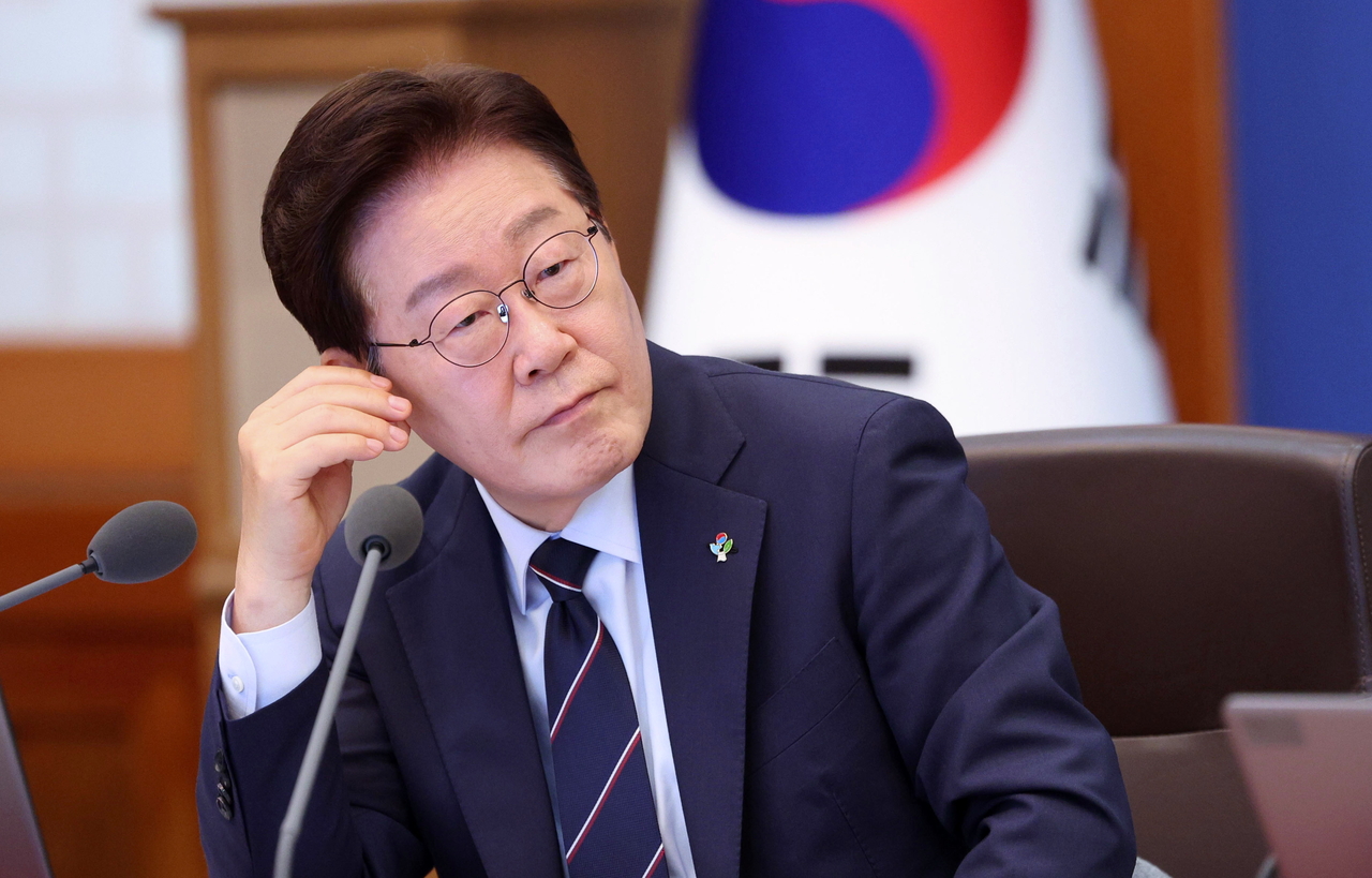 President Lee Jae Myung listens to remarks by attendees during a Cabinet meeting and emergency economic review session at Cheong Wa Dae on Tuesday. (Yonhap)