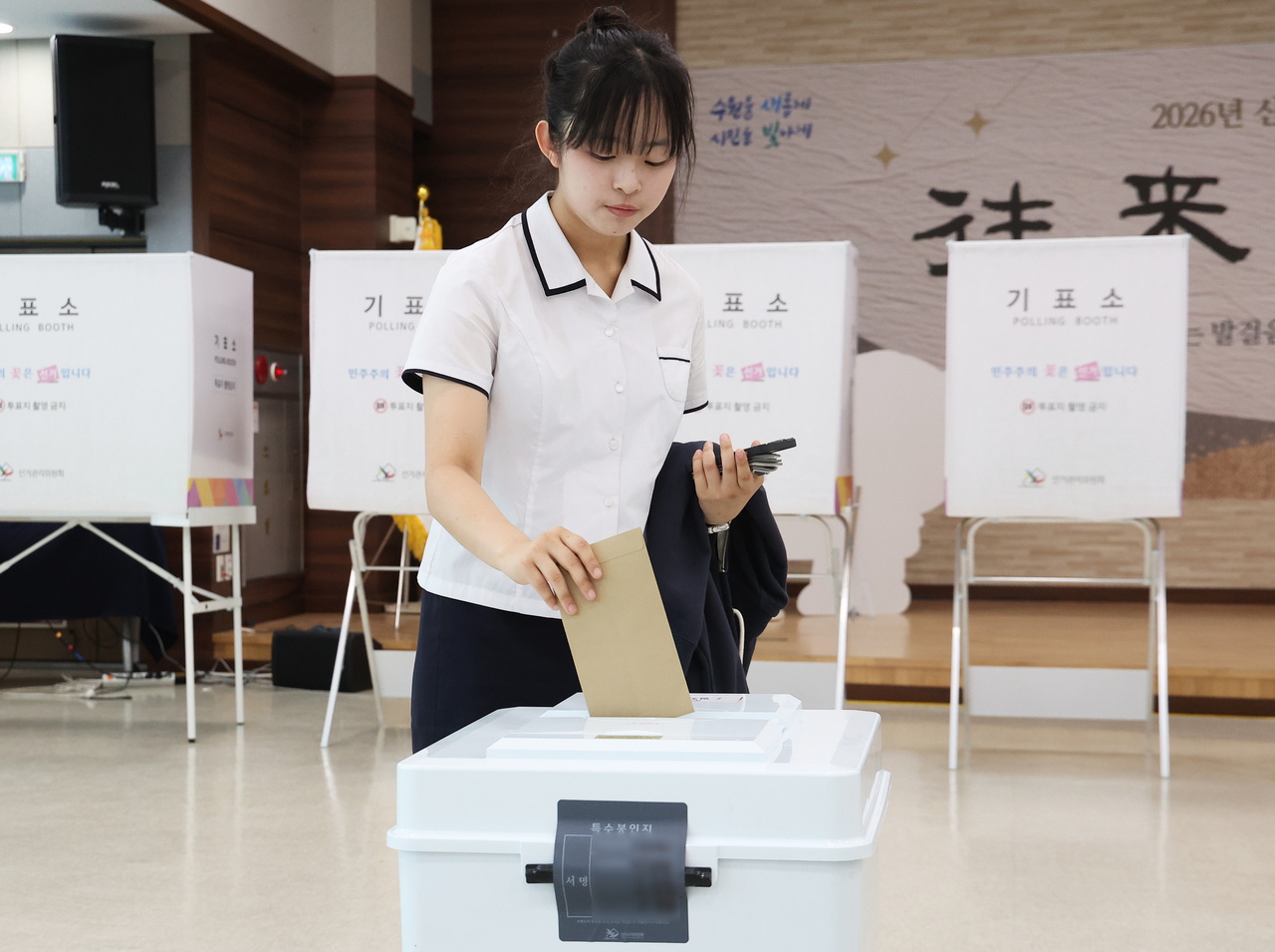 A high school student casts a ballot in Suwon, Gyeonggi Province, on Friday, the first day of early voting. (Yonhap)
