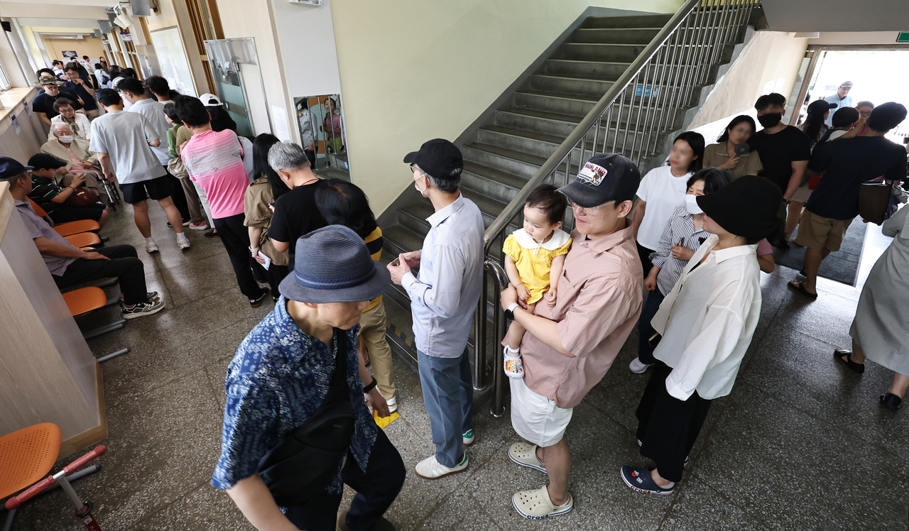 Voters line up at a polling station set up at Yeouido Middle School in Seoul’s Yeongdeungpo-gu on Wednesday during the June 3 local elections. (Yonhap)