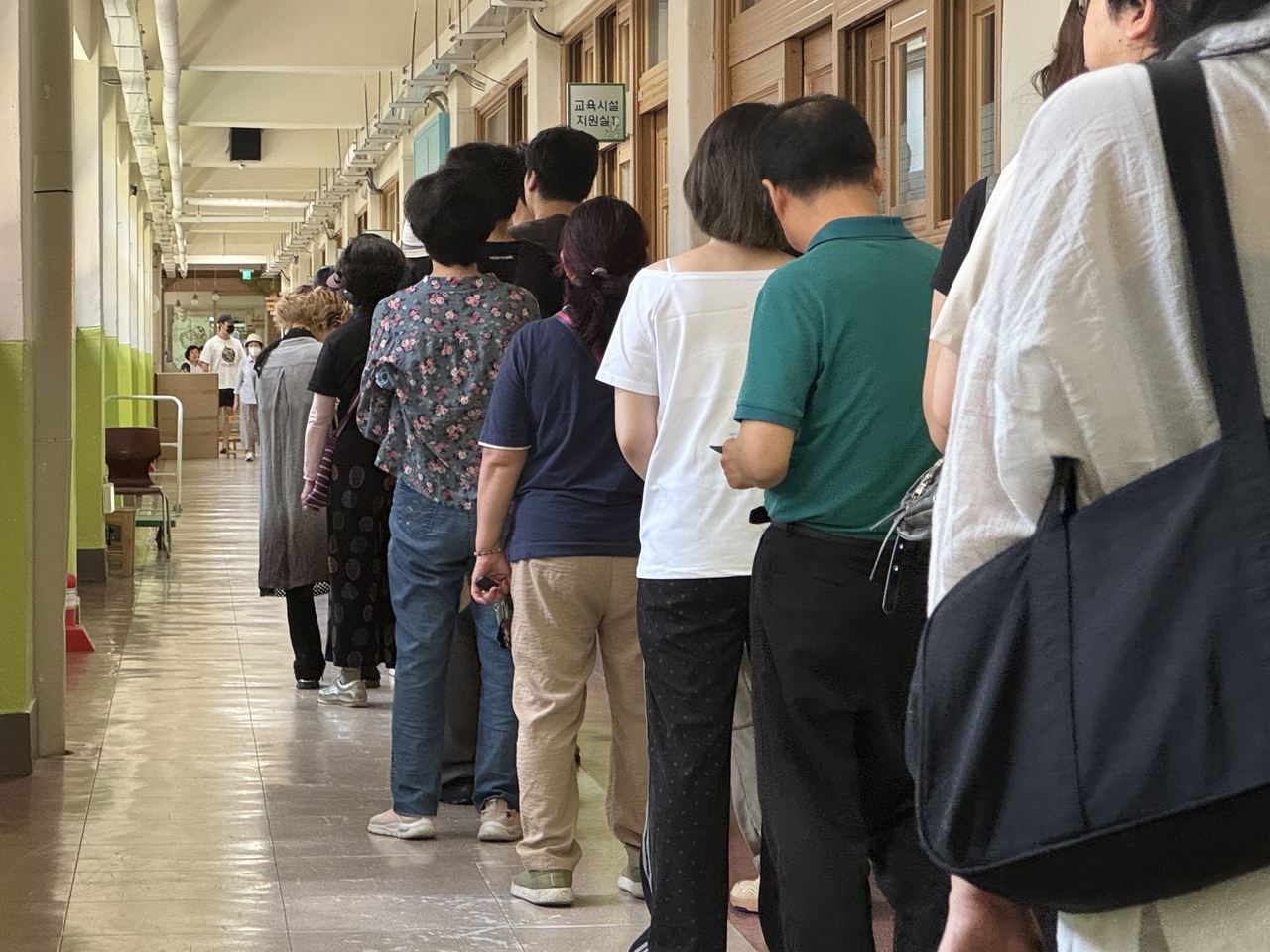 Voters line up in a passage in Seongsan Elementary School in Mapo-gu, western Seoul, on Wednesday to cast their votes. (Cha Min-jung/The Korea Herald)