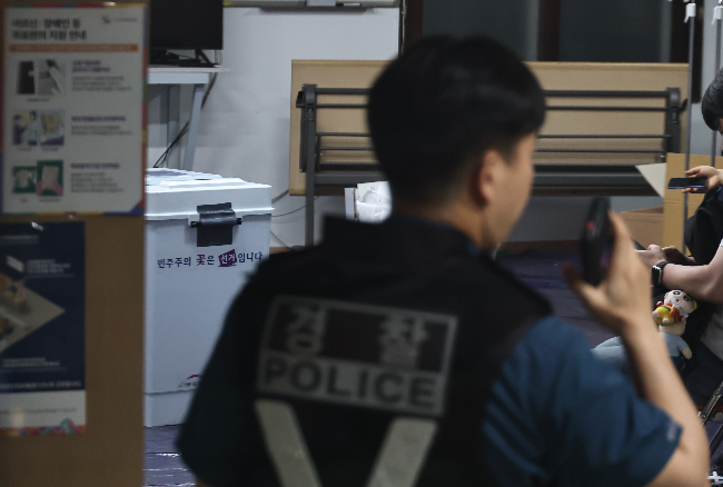 A police officer is seen at  No. 2 polling station in Jamsil 7-dong in eastern Seoul on Wednesday. (Yonhap)